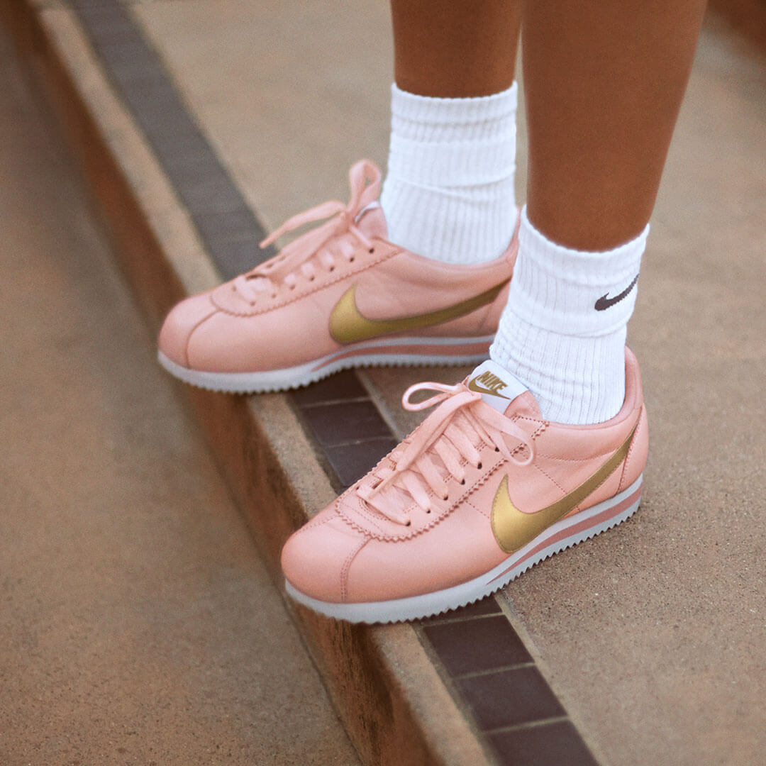 pink nike cortez with gold swoosh